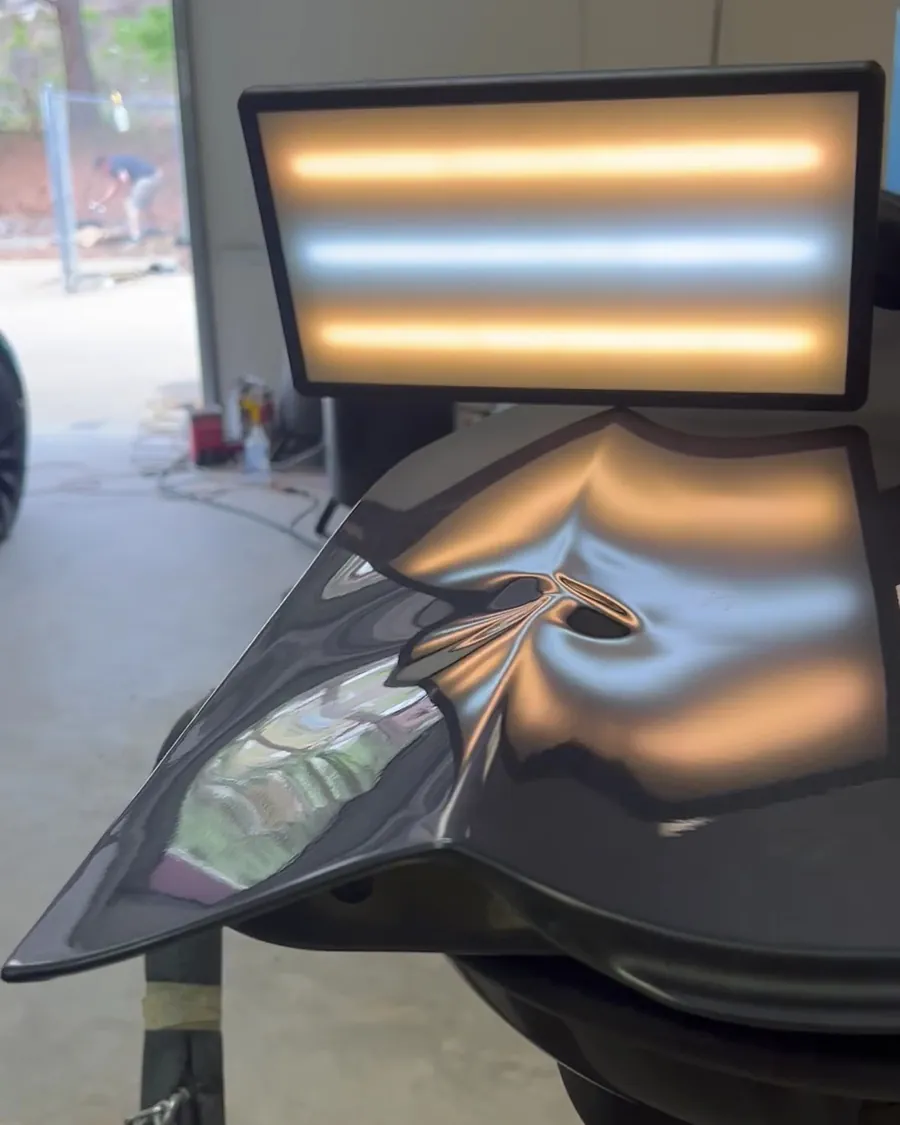 The dent light tool on a dark fender