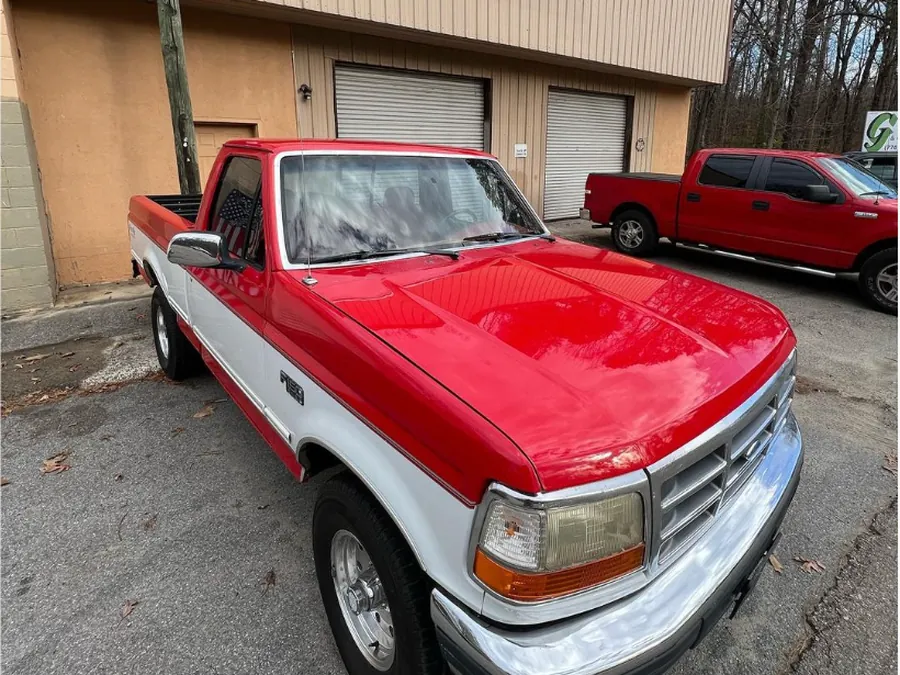 A red and white Ford pickup, freshly painted