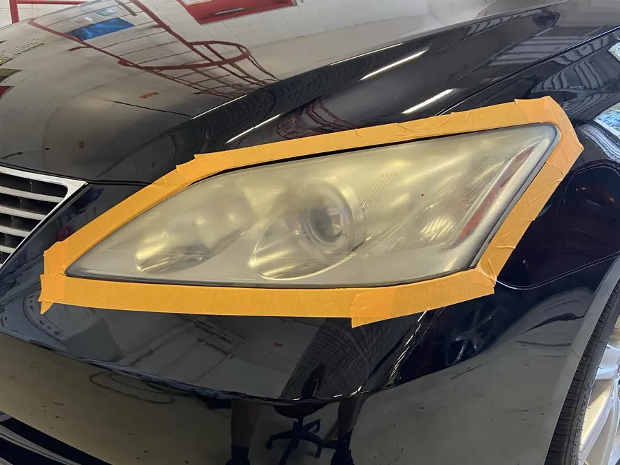 A headlight masked in tape before paint